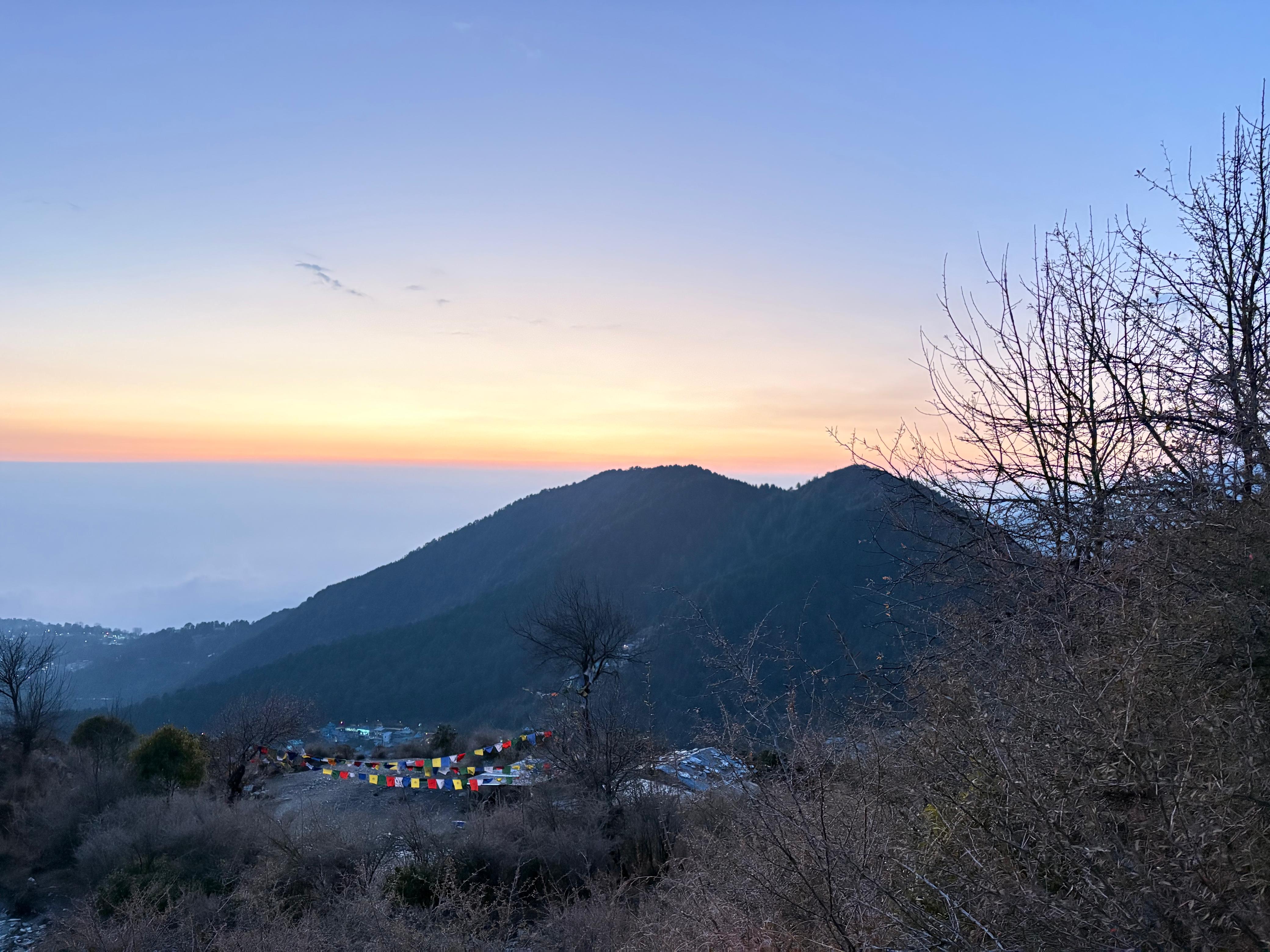 Sunset over Dharamshala valley with Tibetan Buddhist prayer flags, Naddi viewpoint