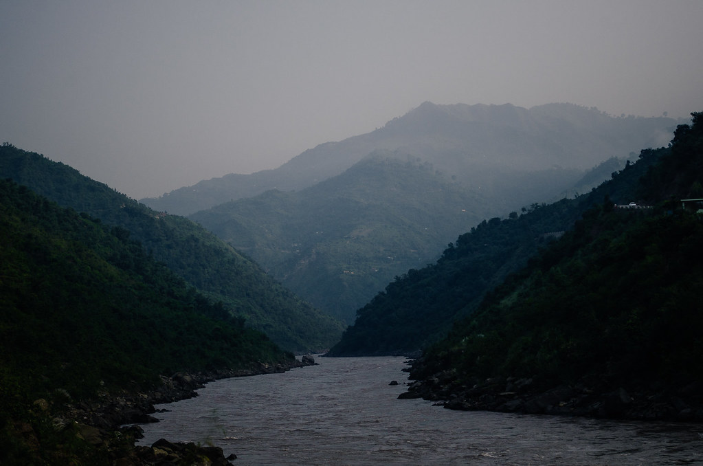 Jhelum River flowing through a deep gorge with misty forested mountains, Kashmir