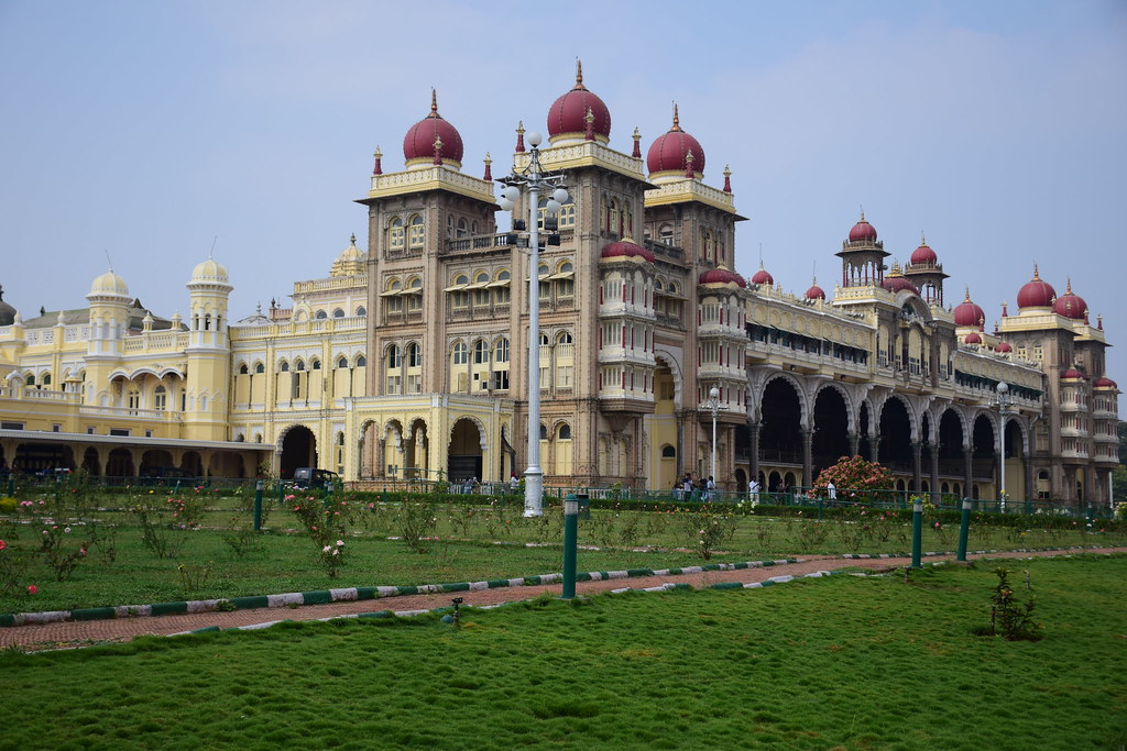 Mysore Palace exterior with red domes and manicured gardens